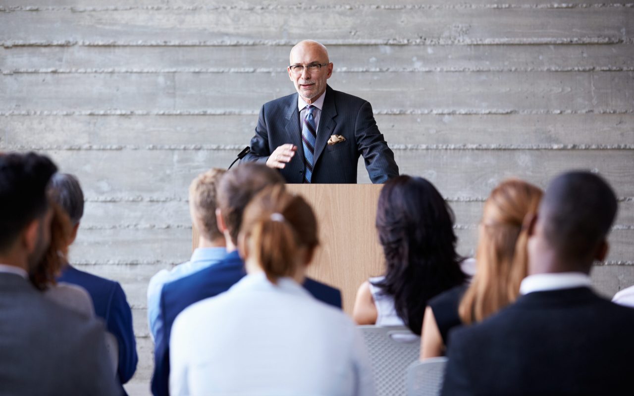 Senior Businessman Addressing Delegates At Conference